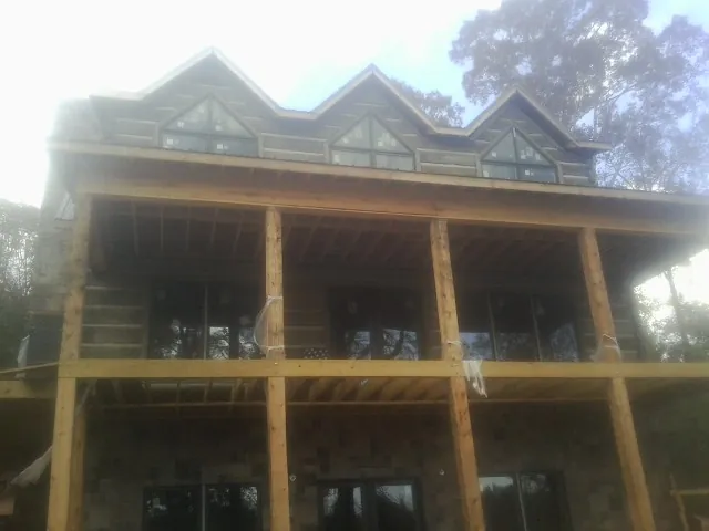 Dormers and porch framing on a large log home under construction — Roof Coating work by our crew in Avalon